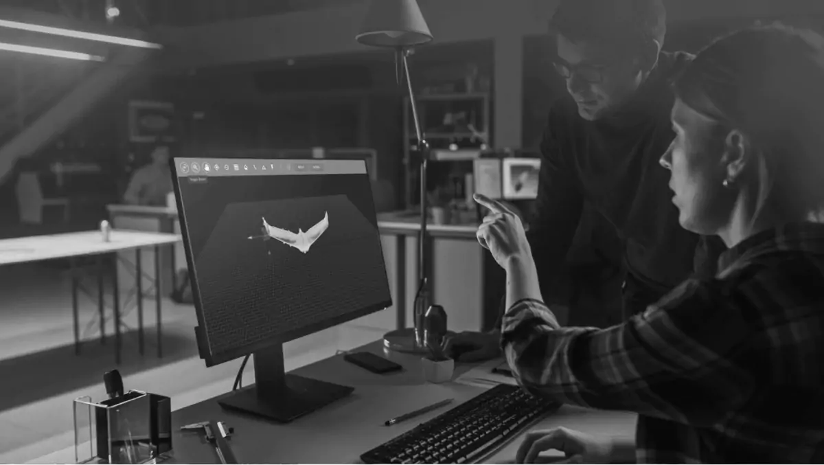 Engineers reviewing a 3D wing shape on a workstation screen, illustrating AI-assisted simulation in design