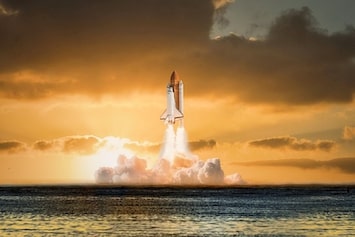 Space shuttle lifting off at sunset over water, symbolising the future of simulation-driven design
