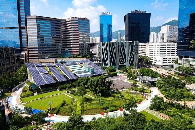 City district with solar panels on a building roof and green park space, illustrating environmental sustainability