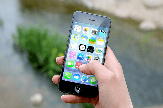 Hand holding a smartphone with app icons, a product once a new design concept and now taken as a given
