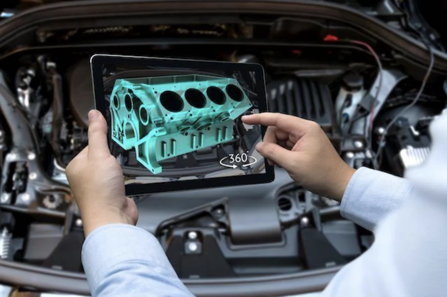 Engineer holding a tablet showing a 3D engine block model in front of a real car engine, illustrating a digital twin