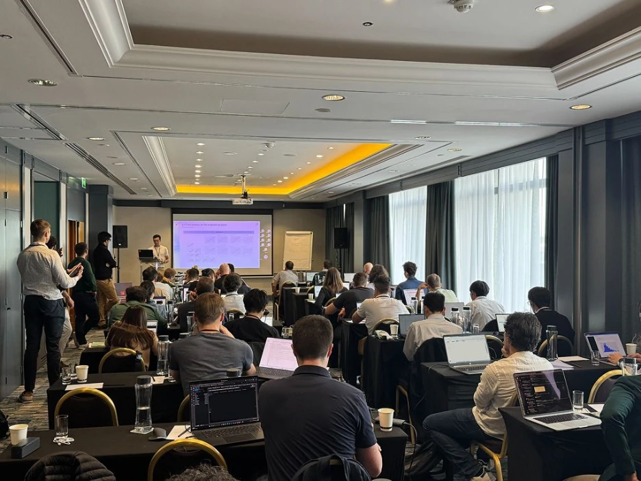 Presenter addressing engineers with laptops in a conference room during a Neural Concept Bootcamp